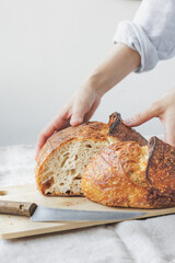 woman cooks homemade yeast-free sourdough bread. Healthy food. a woman baker in a light apron is baking bread in the kitchen, and in a pastry shop she is holding pastries in her hands. confectionery