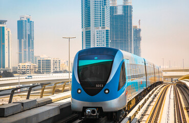 Dubai, UAE. Train, tube track with approaching train and  City view at the distance