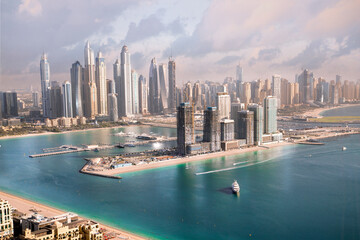 Obraz premium Dubai Marina skyscrapers complex of residential and office buildings at sunset. Yachts and speed boats in the gulf water. Dubai, UAE