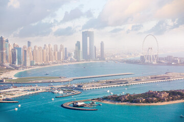 Naklejka premium Dubai Marina skyscrapers complex of residential and office buildings at sunset and Dubai eye. Yachts and speed boats in the gulf water. Dubai, UAE