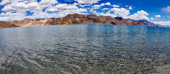 Reflections of Himalayan mountains in clear waters at Pangong Tso Lake in Ladakh in India