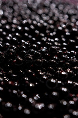 Black pearls close-up. water drops on a surface. wine bubbles. beads. beads on black. drops of water. water drops background. water drops on a glass. 