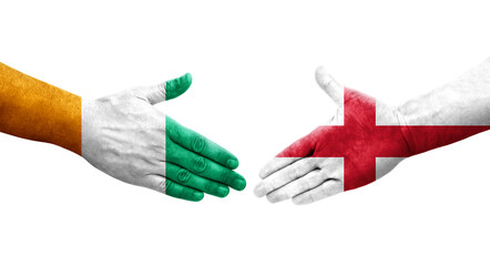Fototapeta premium Handshake between England and Ivory Coast flags painted on hands, isolated transparent image.