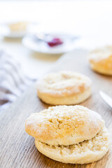 Spezialität zur britischen Teatime: Scones mit Butter und Marmelade auf rustikalem Eichenbrett serviert.