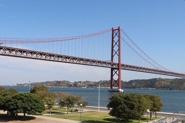 Fototapeta na wymiar Suspended red bridge in Lisbon 