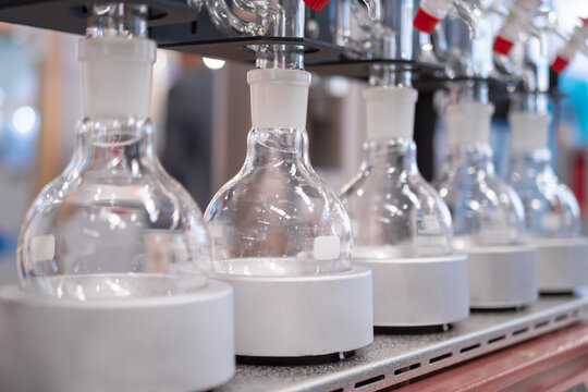 Laboratory equipment - empty glass vials on heating mantle in row. Chemistry, science, pharmaceutical, lab equipment concept