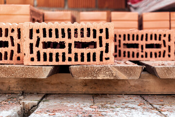 Red ceramic bricks at the construction site. Keramoblock. Hollow brick. Construction of a red brick building. Close-up. Material for the construction of walls and partitions.
