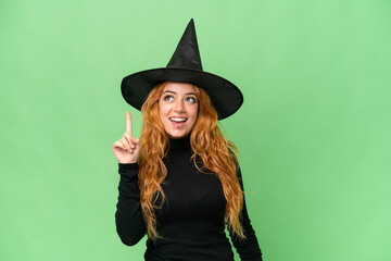 Young caucasian woman costume as witch isolated on green screen chroma key background intending to realizes the solution while lifting a finger up