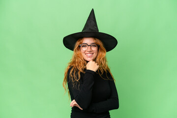 Young caucasian woman costume as witch isolated on green screen chroma key background with glasses and smiling