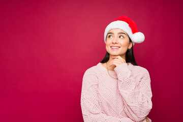Pensive latin woman having christmas dreams and wishes