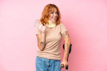 Young caucasian woman wearing neck brace isolated on pink background saluting with hand with happy expression - obrazy, fototapety, plakaty