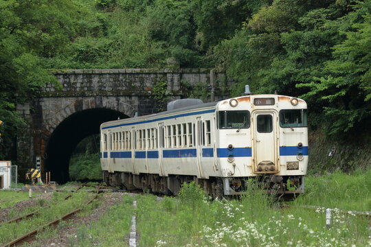 トンネルを出て駅に向かうローカル列車