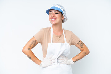 Fishmonger wearing an apron and holding a raw fish isolated on white background posing with arms at hip and smiling