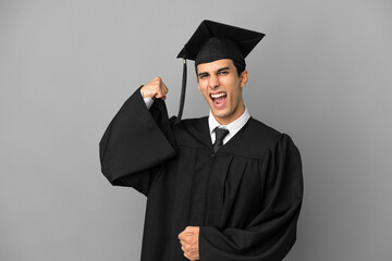 Young Argentinian university graduate isolated on grey background doing strong gesture