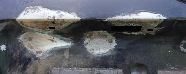 Car rear door corrosion cleaning with rust remover after sanding