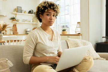 Upset tired exhausted african america young female translator working at home as freelancer sitting...