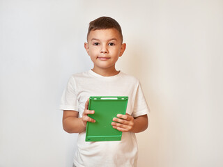 A little boy is holding a tablet in his hands. Teaching aids.