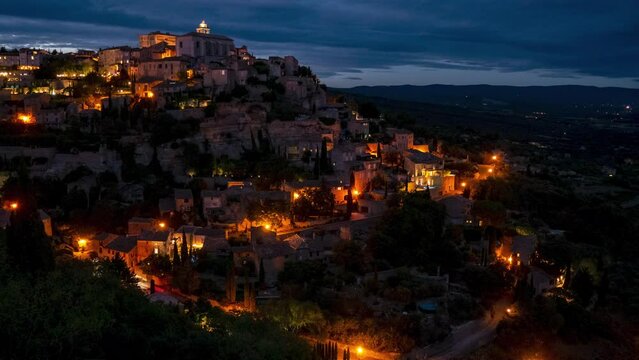 Timelapse of Night Gordes city, Provence Moving cars, clouds, lights at night.