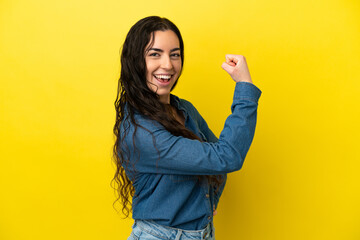 Young caucasian woman isolated on yellow background doing strong gesture