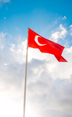 The flag of Turkey is developing in the blue sky.