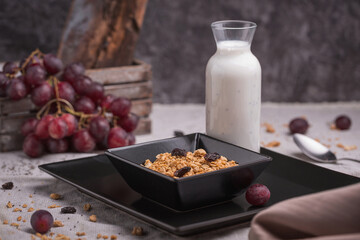 healthy breakfast oatmeal with granola and raisins in a bowl and yogurt with chia