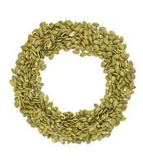 a circle of peeled pumpkin seeds on a white background