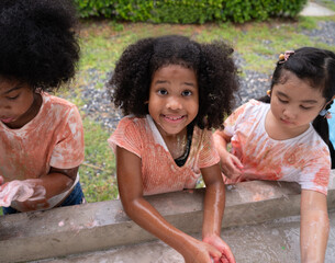 Funny African American kid girls washing hand and rubbing with soap