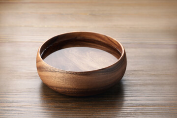 Bowl with pure water on wooden table