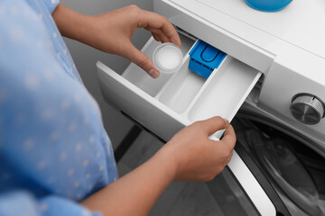 Woman pouring laundry detergent into drawer of washing machine indoors, above view