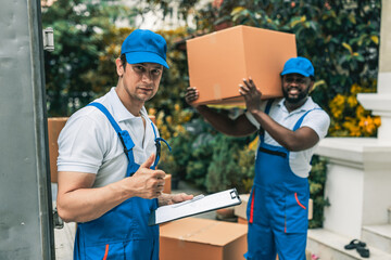 House moving staff is moving a box full of stuff ready for loading into their van infront of customer house.