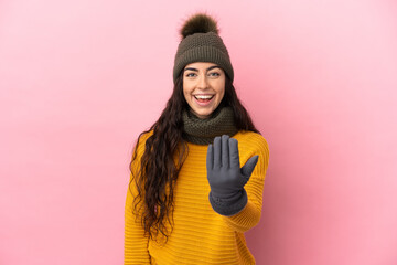 Young caucasian girl with winter hat isolated on purple background inviting to come with hand. Happy that you came