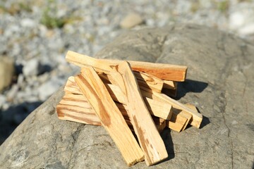 Many palo santo sticks on stone surface, closeup