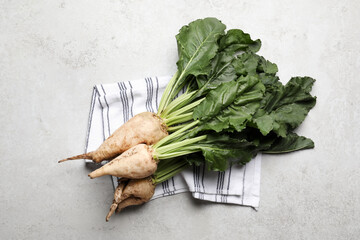 Fresh sugar beets with leaves on light grey table, flat lay