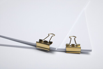 Sheets of paper with clips on white background, closeup