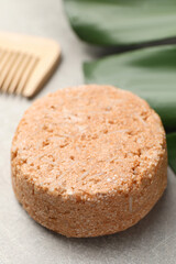 Natural solid shampoo bar on grey table, closeup