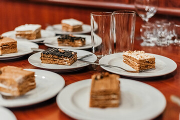 Portions of sweets in plates on the table. Cakes in bowls.