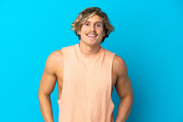 Handsome blonde man isolated on blue background laughing