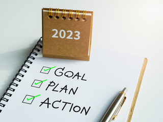 Goal, plan and action, text with checkmarks on notepad with pen and small beige desk calendar on white background. Business motivation, resolution, inspiration concepts.