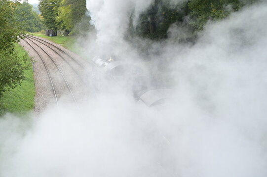 Smoke from a steam engine after passing under a bridge.
