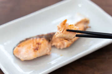 北海道産の焼き鮭を箸で持ち上げている