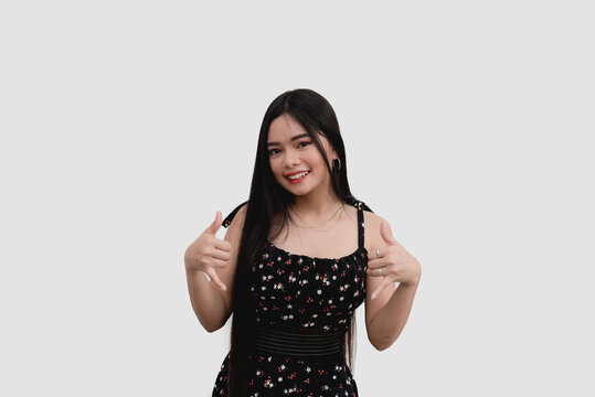 A charming teenager dressed in a floral outfit does the shaka hand sign while smiling for a studio shot isolated on a white background.