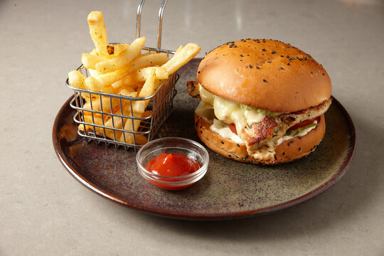 Close up of tasty hamburger and fries on plate