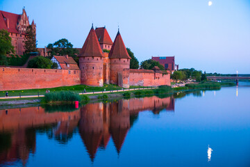 Fototapeta premium Marienburg castle the largest medieval brick castle in the world in the city of Malbork evening view at night