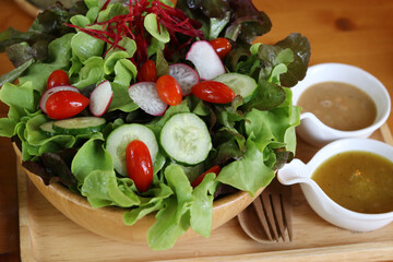 Fresh mixed Vegetable Salad Recipe with Homemade Sauce on wooden plate. 