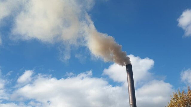 smoke from a chimney against the sky, heating of a cottage with coal, environmental pollution and energy crisis.