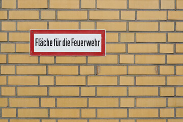 Fototapeta na wymiar Schild an einer Mauer mit der Aufschrift Fläche für die Feuerwehr 