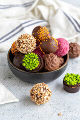 Chocolate praline. Variety of chocolates in bowl on gray background. close up
