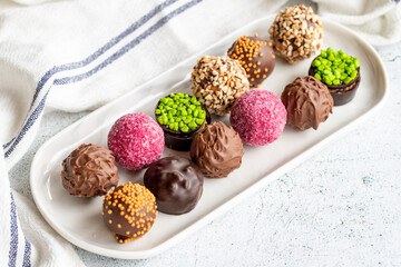 Chocolate praline. Variety of chocolates in bowl on gray background. close up