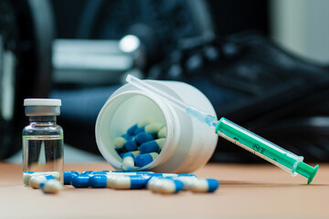 dumbbells, syringe with needle and vial with steroids. illegal doping in sport concept