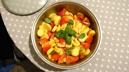 A bowl of fresh tomato salad, potatoes, Tropea onions and basil.